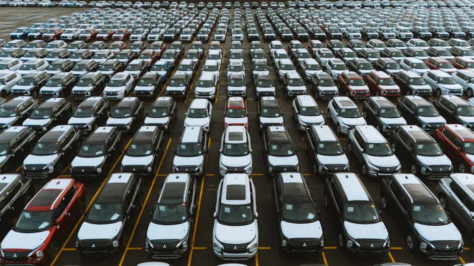 Aerial shot showcasing a vast storage lot filled with parked cars lined up in rows.