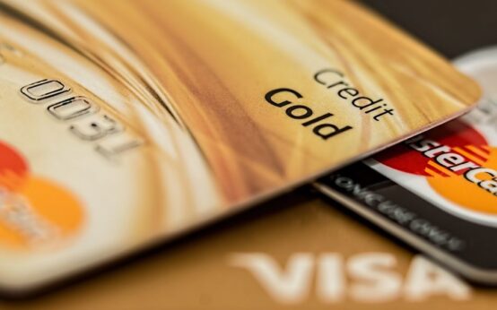 Stack of various branded credit cards focusing on gold card showing finance and cashless concept.