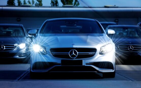 Front view of a lineup of Mercedes-Benz cars with bright headlights, showcasing luxury and elegance.