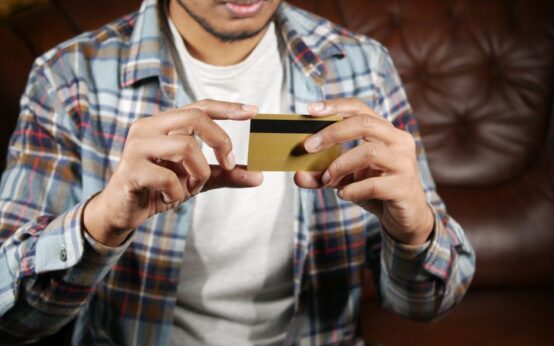 Person holding a credit card, focusing on hands and card for financial themes.
