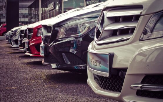 Luxury cars lined up at an outdoor dealership, showcasing sleek designs.