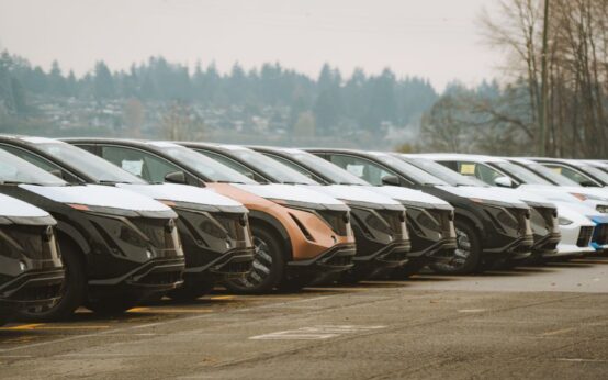 Rows of sleek electric cars parked outdoors, showcasing automotive design and innovation.